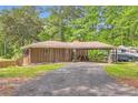 Wide gravel driveway leading to a cozy home with a covered carport perfect for vehicles or outdoor hobbies at 263 Lynn Dr, Fayetteville, GA 30215