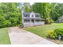 Inviting home featuring a spacious front yard, driveway, and a covered front porch at 5139 Coolamber Dr, Powder Springs, GA 30127