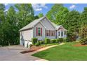 Side view of a well-maintained home with a three-car garage and lush green lawn at 6990 N Glen Dr, Cumming, GA 30028