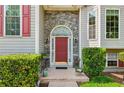 Charming red front door with stone archway and decorative shrubbery at 6990 N Glen Dr, Cumming, GA 30028