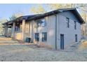 Two-story brick home with a walkout basement, covered porch, and mature trees on a slightly sloping lot at 4011 Lake Carlton Rd, Loganville, GA 30052