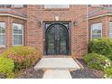 Close-up of an elegant double-door entrance framed by lush greenery and tasteful landscaping at 6932 Dalehollow Dr, Lithonia, GA 30058