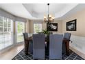 Elegant dining room with tray ceilings and large windows for natural light, seats six at 1130 Lochshyre Way, Lawrenceville, GA 30043