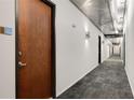 Modern condo hallway with metal ceiling, gray carpet, white walls, and dark wood doors at 130 Arizona Ne Ave # 104, Atlanta, GA 30307