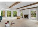 Bright, open living room with beamed ceilings, large windows, and a stone fireplace at 1176 Lullwater Ne Rd, Atlanta, GA 30307