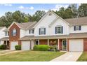 Inviting townhome exterior featuring brick accents, blue shutters, and a cozy covered porch with a beautiful garden at 268 Cottonwood Creek Cir, Canton, GA 30114