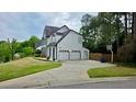 Home exterior with three car garage, basketball hoop, and spacious driveway at 303 Sedgewick Trl, Lawrenceville, GA 30044