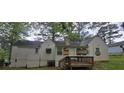 The rear of the home features a small wooden deck and a partially boarded-up back side at 1516 Carter Rd, Decatur, GA 30032