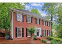 Attractive red brick home with black shutters and a white door, surrounded by mature trees at 1582 E Bank Dr, Marietta, GA 30068