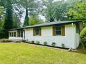 Attractive single-story home featuring white brick, wood shutters, and green front lawn at 2011 W Starmount Way, Decatur, GA 30032