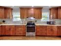 Updated kitchen with wood cabinets, granite countertops, stainless steel appliances, and white marble backsplash at 2944 Berry Rd, Loganville, GA 30052