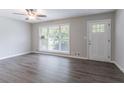 Bright, open living area with hardwood floors, fan and a large window at 5795 Deerfield Trl, Atlanta, GA 30349