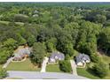 Aerial view showcases the home's position among mature trees, as well as the neighborhood at 1605 Little Lisa Ln, Snellville, GA 30078