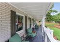 Covered front porch with seating and a gray deck overlooking the landscaped yard at 185 Pamela Nw St, Marietta, GA 30064