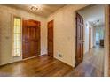 Inviting foyer with hardwood floors, detailed wallpaper and a solid wood front door at 1850 Francis Sw Rd, Conyers, GA 30094