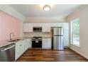 Modern kitchen with stainless steel appliances, granite countertops, and white cabinetry at 3990 Howell Park Rd, Duluth, GA 30096