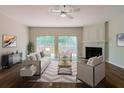 Bright living room featuring a fireplace, hardwood floors, and sliding glass doors to a deck at 3990 Howell Park Rd, Duluth, GA 30096