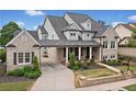 Charming exterior view of a brick home showcasing a covered porch, manicured shrubs, and a driveway at 487 Carmichael Cir, Canton, GA 30115