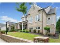 Lovely exterior displaying a covered porch with columns, tasteful landscaping, and brick details at 487 Carmichael Cir, Canton, GA 30115