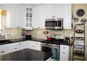Well-lit kitchen featuring white cabinets, stainless steel appliances, and decorative backsplash at 3606 Packhorse Run, Marietta, GA 30066