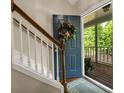 Inviting entryway with wood staircase and a wreath adorned door that leads to the large front porch at 4112 Willow Sw Walk, Lilburn, GA 30047