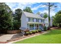 Charming blue home with a well-kept lawn, inviting front porch, and a detached garage at 4994 Willow Creek Dr, Woodstock, GA 30188