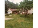 Inviting single-story home featuring a front porch, an attached garage, and a spacious front yard at 6690 Jenkins Rd, Fairburn, GA 30213