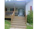 Inviting front porch with steps leading up to the entrance, framed by wooden railings and decorative accents at 6690 Jenkins Rd, Fairburn, GA 30213