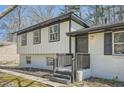 Stunning exterior showcasing a well-maintained front porch with stylish black shutters and landscaping at 6552 King George Way, Morrow, GA 30260