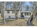 Charming home featuring mature trees, a brick facade, and a welcoming front porch at 6552 King George Way, Morrow, GA 30260