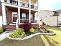 The front of the house is well landscaped with green grass, plants, and decorative rock edging at 4071 Woodward Walk Ln, Suwanee, GA 30024