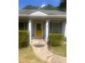 Close up of the front door with vibrant yellow paint and well manicured front yard at 497 Natasha Dr, Auburn, GA 30011