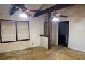 View of living room with two ceiling fans, large windows, and wall damage at 2368 Ebenezer Se Rd, Conyers, GA 30094