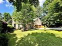 Attractive brick home with lush green lawn, mature trees, and a basketball hoop, perfect for Gathering living at 5105 Tynewick Ne Trce, Roswell, GA 30075