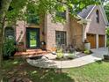 Inviting brick home with a decorative front door, lush landscaping, and a cozy front porch area at 5105 Tynewick Ne Trce, Roswell, GA 30075