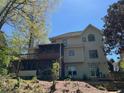 Two-story home featuring a screened-in porch, wood deck, and lush green yard at 5105 Tynewick Ne Trce, Roswell, GA 30075