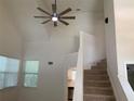 Open living room with high ceilings, staircase, ceiling fan, and abundant natural light at 76 Burbank Dr, Atlanta, GA 30314