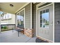 Covered front porch featuring stone accents, a bench, and stylish door at 7698 Hansel Ln, Lithonia, GA 30058