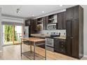 Updated kitchen featuring stainless steel appliances, granite countertops, and hardwood floors at 1360 Peter Haughton Nw Way, Atlanta, GA 30318