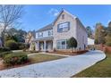 Beautiful home featuring brick accents, manicured landscaping and a long concrete driveway on a sunny day at 20 Daniel Crk, Sugar Hill, GA 30518