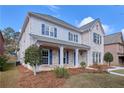 Elegant two-story home with a brick and siding exterior, enhanced by a cozy front porch and lush landscaping at 20 Daniel Crk, Sugar Hill, GA 30518