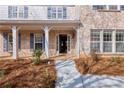 Inviting front porch featuring white columns, brick accents, and a partially open front door at 20 Daniel Crk, Sugar Hill, GA 30518