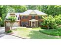 Traditional brick home with a well-maintained lawn, mature trees, and an attached two-car garage at 1855 Vintage Dr, Snellville, GA 30078