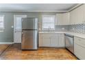 Kitchen with stainless steel refrigerator and white cabinets, sink, and backsplash and wood-look floors at 2586 Williamsburg Dr, Decatur, GA 30034