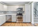 Kitchen with stainless steel appliances and white cabinets, and access to staircase to upper level at 2586 Williamsburg Dr, Decatur, GA 30034