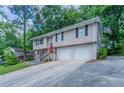 Side angle of a split level home featuring a large front yard and attached two car garage at 3938 Emerald Springs Ct, Decatur, GA 30035