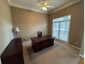 Cozy home office featuring a ceiling fan, carpet and natural light from a window at 4055 Vista Point Ln, Suwanee, GA 30024