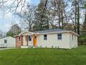 Charming single story home with an orange door, well maintained lawn and mature trees at 904 Fairburn Nw Pl, Atlanta, GA 30331