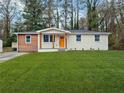 Charming single story home with an orange door, well maintained lawn and mature trees at 904 Fairburn Nw Pl, Atlanta, GA 30331