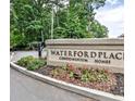 Waterford Place Condominium Homes sign surrounded by landscaped flower beds and mature trees at 802 Lismore Se # 2, Smyrna, GA 30080